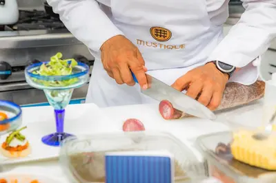 a chef cutting a piece of meat with a knife at Casa La Merced by Mustique in Cartagena de Indias