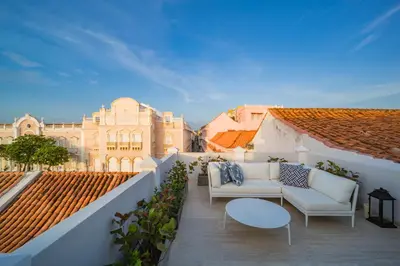 a balcony with a couch and a table and a building at Casa La Merced by Mustique in Cartagena de Indias