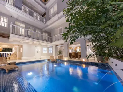 a large swimming pool in a large house with a large ceiling at Casa La Merced by Mustique in Cartagena de Indias
