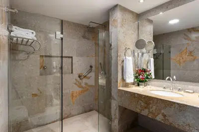 a bathroom with a glass shower and a sink at Hotel Las Americas Casa de Playa in Cartagena de Indias