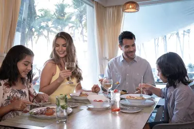 a family sitting at a table eating dinner at Hotel Las Americas Casa de Playa in Cartagena de Indias