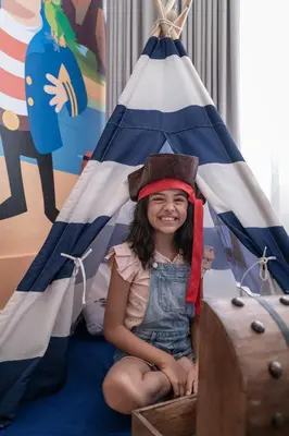 a little girl sitting in a pirate tent at Hotel Las Americas Casa de Playa in Cartagena de Indias