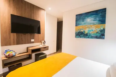 a hotel room with a bed and a flat screen tv at Hotel Zi One Luxury in Cartagena de Indias