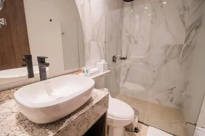a white bathroom with a sink and a shower at Hotel Zi One Luxury in Cartagena de Indias