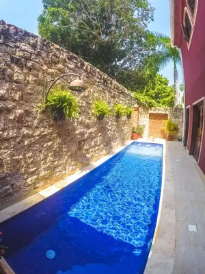 a blue swimming pool next to a brick wall at Hotel Casa La Tablada Manga in Cartagena de Indias