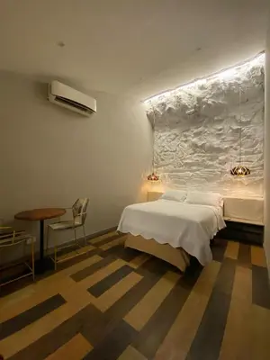 a bedroom with a bed and a table and a chair at Hostel la Antigua Capsula in Cartagena de Indias