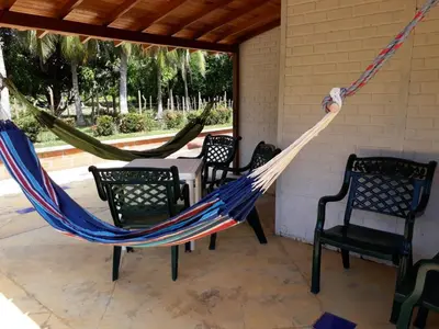 a patio with two hammocks and a table and chairs at El palmar azul in San Bernardo del Viento