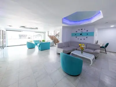 a living room with a couch and blue chairs at Hotel Caribe Plaza Barranquilla in Barranquilla