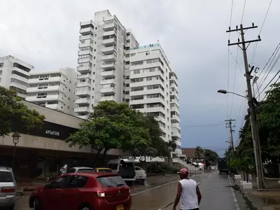 a man walking down a street in front of a tall building at Caribe a Vista in Cartagena de Indias