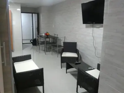 a room with chairs and tables and a television on a wall at Caribe a Vista in Cartagena de Indias