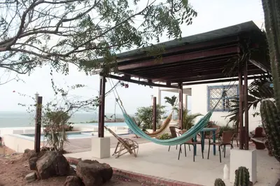 a porch with a hammock and a pool at Frente al Mar in Santa Veronica