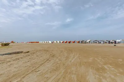 a sandy beach with a group of umbrellas in the background at Escapada 5 estrellas frente al mar - sonest morros in Cartagena de Indias