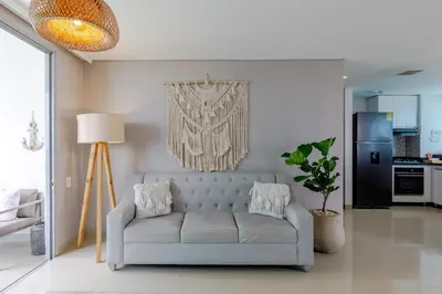 a living room with a couch and a kitchen at Escapada 5 estrellas frente al mar - sonest morros in Cartagena de Indias