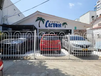 a gate with cars parked in front of a store at Costana - Hostal in Cartagena de Indias