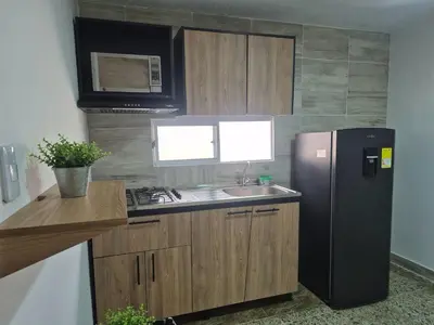 a kitchen with a black refrigerator and a sink at Costana - Hostal in Cartagena de Indias