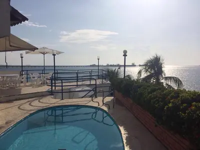 a swimming pool next to a body of water at Casa Miramar in Santa Marta