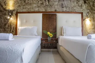 two beds in a hotel room with white sheets at Hotel Virrey Cartagena in Cartagena de Indias