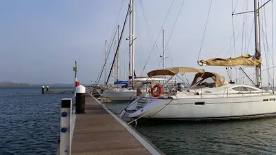 a white boat docked at a dock with other boats at cabaña puerto velero in Puerto Caimán