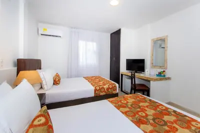 a hotel room with two beds and a television at Hotel Playa Club in Cartagena de Indias