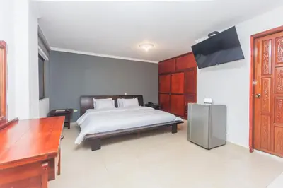 a bedroom with a bed and a flat screen tv at Hotel Baluarte Cartagena Boutique in Cartagena de Indias
