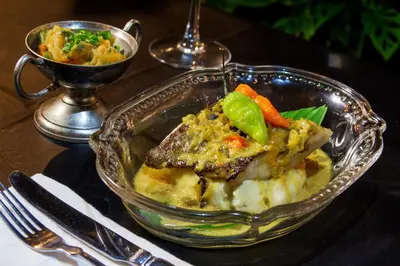 a glass dish of food with meat and vegetables on a table at Hotel Casa Lola Deluxe Gallery in Cartagena de Indias