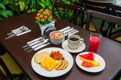 a table with plates of food and a cup of coffee at Hotel Aixo Suites By GEH Suites in Cartagena de Indias