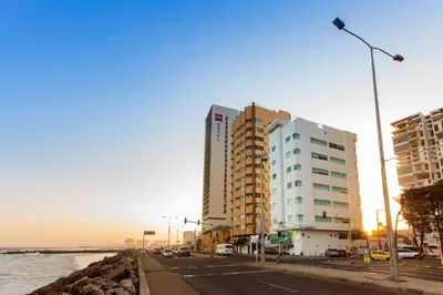 a building on a street next to the ocean at Hotel Aixo Suites By GEH Suites in Cartagena de Indias