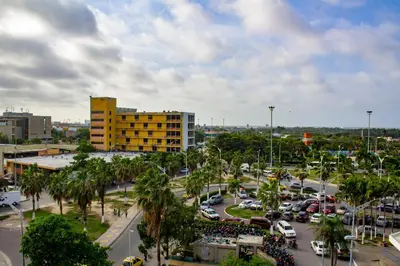 a city with a parking lot and a yellow building at Hotel Med Barranquilla Centro in Barranquilla