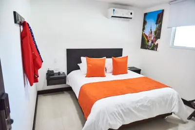 a bedroom with a large bed with orange pillows at Hotel G Cartagena in Cartagena de Indias