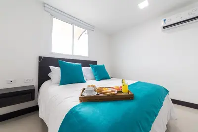 a bedroom with a bed with a tray of food on it at Hotel G Cartagena in Cartagena de Indias