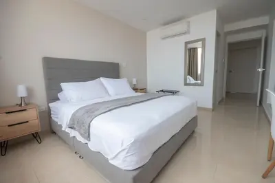 a bedroom with a large bed with white sheets and pillows at Hotel Stil Cartagena in Cartagena de Indias