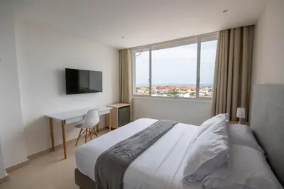a bedroom with a bed and a desk and a window at Hotel Stil Cartagena in Cartagena de Indias