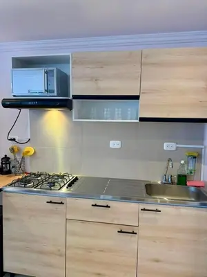 a kitchen with a stove top and wooden cabinets at Apartamentos Cartagena Colonial in Cartagena de Indias
