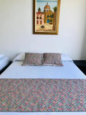 a bed in a room with a picture on the wall at Apartamentos Cartagena Colonial in Cartagena de Indias