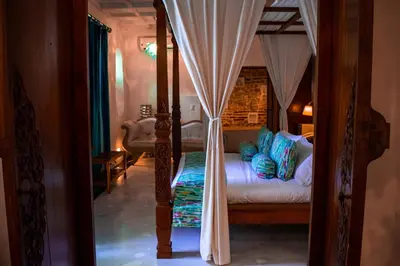 a bedroom with a canopy bed with curtains at Hotel Aguamarina Boutique in Cartagena de Indias