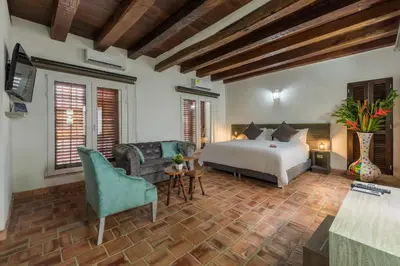 a bedroom with a bed and a couch and a tv at Getsemani Cartagena Hotel in Cartagena de Indias