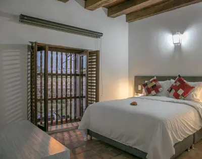a bedroom with a large bed and a window at Getsemani Cartagena Hotel in Cartagena de Indias