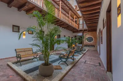 a courtyard with benches and a tree in a building at Getsemani Cartagena Hotel in Cartagena de Indias