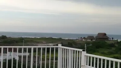 a view of the ocean from the balcony of a house at Cabaña Villa Flower Gold in Juan de Acosta