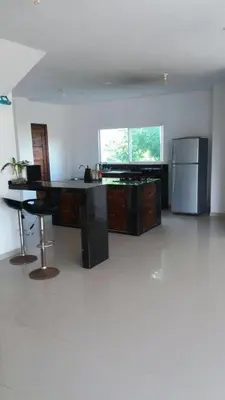 a kitchen with a desk and a refrigerator at Cabaña Villa Flower Gold in Juan de Acosta