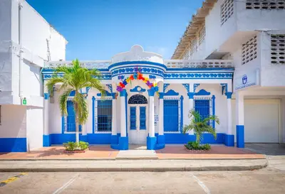a blue and white building with palm trees in front at Casa Caribe Colonial in Barranquilla
