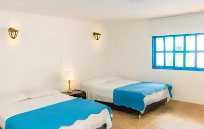 a bedroom with two beds and a window at Casa Caribe Colonial in Barranquilla