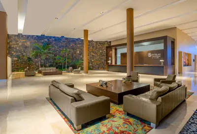 a lobby with couches and a table in a building at Estelar Alto Prado in Barranquilla