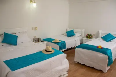 a room with three beds with hats on them at Casa Villa Colonial By Akel Hotels in Cartagena de Indias