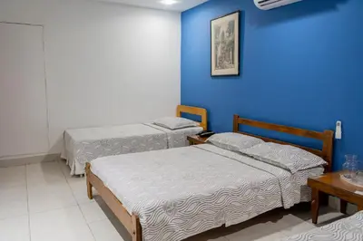 two beds in a room with a blue wall at Hotel Veleros Cartagena in Cartagena de Indias