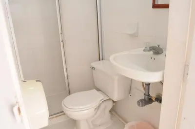 a white bathroom with a toilet and a sink at Hotel Montecarlo Beach in Tolú