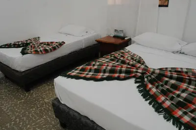 two beds with scarves on them in a room at Hotel Montecarlo Beach in Tolú