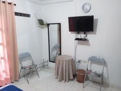 a room with two chairs and a table and a tv at Comfort La Española in Cartagena de Indias