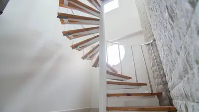 a wooden staircase in a room with a brick wall at Hotel Santa Cecilia B&B in Cartagena de Indias