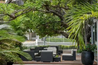 a patio with black and white furniture and trees at NH Collection Royal Smartsuites in Barranquilla